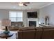 Cozy living room with a fireplace, mounted TV, hardwood floors, and a ceiling fan at 513 Forest Ln, Canton, GA 30114