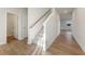 Hallway featuring carpeted stairs leading to the second floor, wood-look floors, and neutral walls at 2635 Mourning Dove Dr. (Lot 48), Grayson, GA 30017