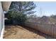 A fenced backyard features dormant grass and a large shade tree at 6715 Biscayne Blvd, Rex, GA 30273