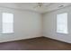 Spacious carpeted bedroom with a ceiling fan and natural light from two windows at 6715 Biscayne Blvd, Rex, GA 30273