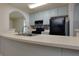 Close up of the kitchen area with black appliances and archway leading to the living area at 6715 Biscayne Blvd, Rex, GA 30273