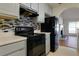 A close up of the kitchen featuring black appliances, backsplash and views of the living room at 6715 Biscayne Blvd, Rex, GA 30273