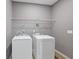 Functional laundry room includes washer, dryer, and wire shelf at 950 Mill Creek Ave, Canton, GA 30115