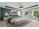 This main bedroom features a tray ceiling, wood accent wall, ceiling fan and ensuite sitting area at 950 Mill Creek Ave, Canton, GA 30115