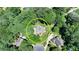 Aerial view shows the home nestled among mature trees, providing privacy at 9585 Fenbrook Ct, Johns Creek, GA 30022