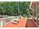 Inviting back deck with bench seating surrounded by mature trees and nature views at 9585 Fenbrook Ct, Johns Creek, GA 30022