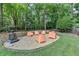 Backyard with a firepit area and contemporary chairs nestled in mature trees at 9585 Fenbrook Ct, Johns Creek, GA 30022