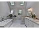 Bright bathroom with marble floors, skylights, a soaking tub, and a dual-sink vanity at 9585 Fenbrook Ct, Johns Creek, GA 30022