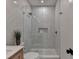Bathroom with glass shower, rainfall shower head, floating vanity, and patterned tile floor at 9585 Fenbrook Ct, Johns Creek, GA 30022