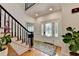 Elegant foyer featuring a decorative front door, staircase with dark wood railing, and hardwood floors at 9585 Fenbrook Ct, Johns Creek, GA 30022