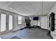 Basement gym with mirrored wall, gym equipment, and an exterior door to the yard at 9585 Fenbrook Ct, Johns Creek, GA 30022