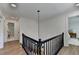 Hallway with wood floors, black railing, crown molding, and access to bathroom and bedroom at 9585 Fenbrook Ct, Johns Creek, GA 30022