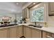 Kitchen with stainless steel sink, gas range, and a view of the living room with fireplace at 9585 Fenbrook Ct, Johns Creek, GA 30022