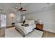 Main bedroom featuring a tray ceiling, fan, wood floors, and neutral décor at 9585 Fenbrook Ct, Johns Creek, GA 30022