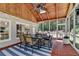 Enclosed patio features wood ceiling with skylight, ceiling fan, tile floor and screened windows at 9585 Fenbrook Ct, Johns Creek, GA 30022