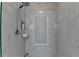 Modern bathroom shower featuring elegant marble tile surround and recessed shelf storage at 9585 Fenbrook Ct, Johns Creek, GA 30022