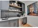 Elegant wet bar with black backsplash, open shelving, and wine cooler at 9585 Fenbrook Ct, Johns Creek, GA 30022
