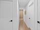 Bright hallway featuring hardwood floors, white walls, and modern doors leading to various rooms at 2356 Sherbrooke Ne Dr, Atlanta, GA 30345