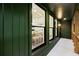 Covered patio featuring green wood siding, brick accent wall, and views to the dining room at 2356 Sherbrooke Ne Dr, Atlanta, GA 30345