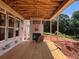 Covered back porch featuring a fireplace, wood flooring, and ample space for outdoor living and entertainment at 2759 S Waterworks Rd, Buford, GA 30518