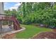 Landscaped backyard featuring a wooden deck, stone walkway, and mature trees at 640 Windwalk Dr, Roswell, GA 30076
