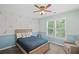 Cozy bedroom with blue walls and white trim features a window with shutters, soft carpet, and a comfortable chair at 640 Windwalk Dr, Roswell, GA 30076