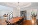 Elegant dining room boasts hardwood floors, coffered ceilings, and a modern chandelier with views of the staircase at 640 Windwalk Dr, Roswell, GA 30076