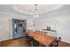 Elegant dining room boasts hardwood floors, coffered ceilings, and a modern chandelier with bar cabinet at 640 Windwalk Dr, Roswell, GA 30076