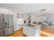 Bright kitchen features white cabinets, stainless steel appliances, granite counters, and an island cooktop at 640 Windwalk Dr, Roswell, GA 30076