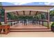 Outdoor covered patio with ceiling fan, mounted heaters, bar, and seating overlooking tennis court at 640 Windwalk Dr, Roswell, GA 30076