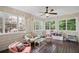 Bright sunroom features wood floors, lots of windows, and comfortable seating for relaxing or entertaining guests at 640 Windwalk Dr, Roswell, GA 30076