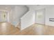 Open-concept living room with wood-look flooring, bright windows, staircase, and electric fireplace at 2645 Mourning Dove Drive (Lot 49), Grayson, GA 30017