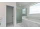 Luxurious bathroom with a glass-enclosed shower and a soaking tub featuring marble-look tile at 348 Olmstead Way # 30, Alpharetta, GA 30022