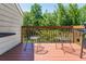 The outdoor back deck features a wooden deck and railings surrounded by lush green trees and foliage at 442 Colonial Walk, Woodstock, GA 30189