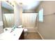 Bright bathroom features a tiled floor, white shower curtain, and standard single sink vanity at 442 Colonial Walk, Woodstock, GA 30189