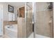 Bright bathroom featuring tiled walls, soaking tub, and separate tiled glass-enclosed shower at 442 Colonial Walk, Woodstock, GA 30189