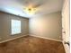 Bare bedroom features neutral walls, carpet, ceiling fan, and double door closet at 442 Colonial Walk, Woodstock, GA 30189