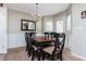 A dining room featuring a chandelier over a dark wood table, with large windows bringing in lots of light at 442 Colonial Walk, Woodstock, GA 30189