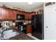 The well-lit kitchen features dark granite counters, wood cabinets, and modern black appliances at 442 Colonial Walk, Woodstock, GA 30189