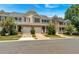 Street view of inviting townhomes with attached garages, lush greenery, and beautiful flowering trees, offering modern living at 442 Colonial Walk, Woodstock, GA 30189