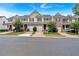 Well-maintained townhomes feature attached garages, manicured lawns, and tree-lined street for curb appeal at 442 Colonial Walk, Woodstock, GA 30189