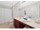 Clean bathroom featuring a toilet, shower with white curtain, and vanity with cream countertop at 6018 Oakdale Se Rd, Mableton, GA 30126