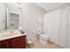 Bright bathroom featuring a toilet, shower with white curtain, and vanity with cream countertop at 6018 Oakdale Se Rd, Mableton, GA 30126