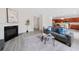 Inviting living room with fireplace, gray sofa, modern art, and views into a bright kitchen at 6018 Oakdale Se Rd, Mableton, GA 30126