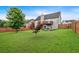Grassy backyard featuring a wooden fence, shade tree and adjacent deck at 218 Depot Ln, Dallas, GA 30157