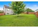 Spacious backyard with green grass, mature tree, and a wood privacy fence at 218 Depot Ln, Dallas, GA 30157