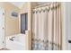 A clean bathroom featuring a bathtub and shower with a decorative shower curtain and neutral colored walls at 218 Depot Ln, Dallas, GA 30157
