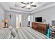 Bright bedroom with a tray ceiling, comfortable bed, and a large dresser with a TV at 218 Depot Ln, Dallas, GA 30157