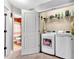 Functional laundry room with modern washer and dryer, shelving, and doorway to a bathroom at 218 Depot Ln, Dallas, GA 30157