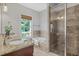 Bathroom with double vanity, soaking tub under window, and a tiled walk-in shower at 2817 Lincoln Dr, Decatur, GA 30033